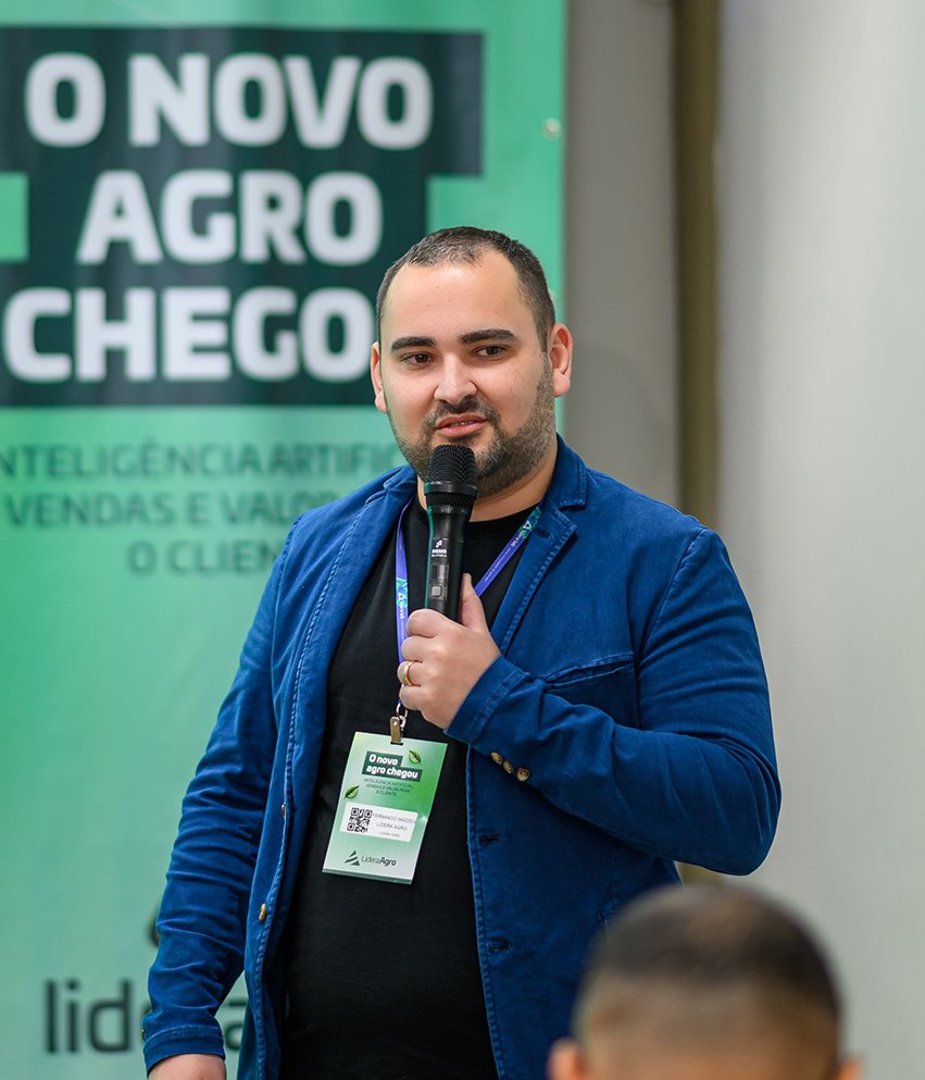 Fernando Mazzeu falando ao microfone diante do painel de um evento de IA no agronegócio